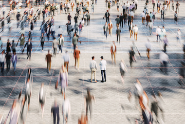 Business professionals standing together on a city street discussing business structure strategy.