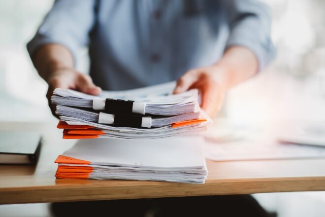 Siepert accountant stacking audit review papers on a desk top